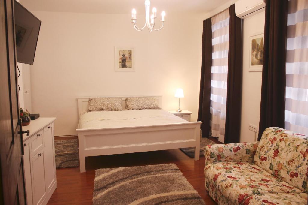 ein Schlafzimmer mit einem Bett, einem Sofa und einem Kronleuchter in der Unterkunft Studio apartment Zagorka Tkalčićeva street in Zagreb