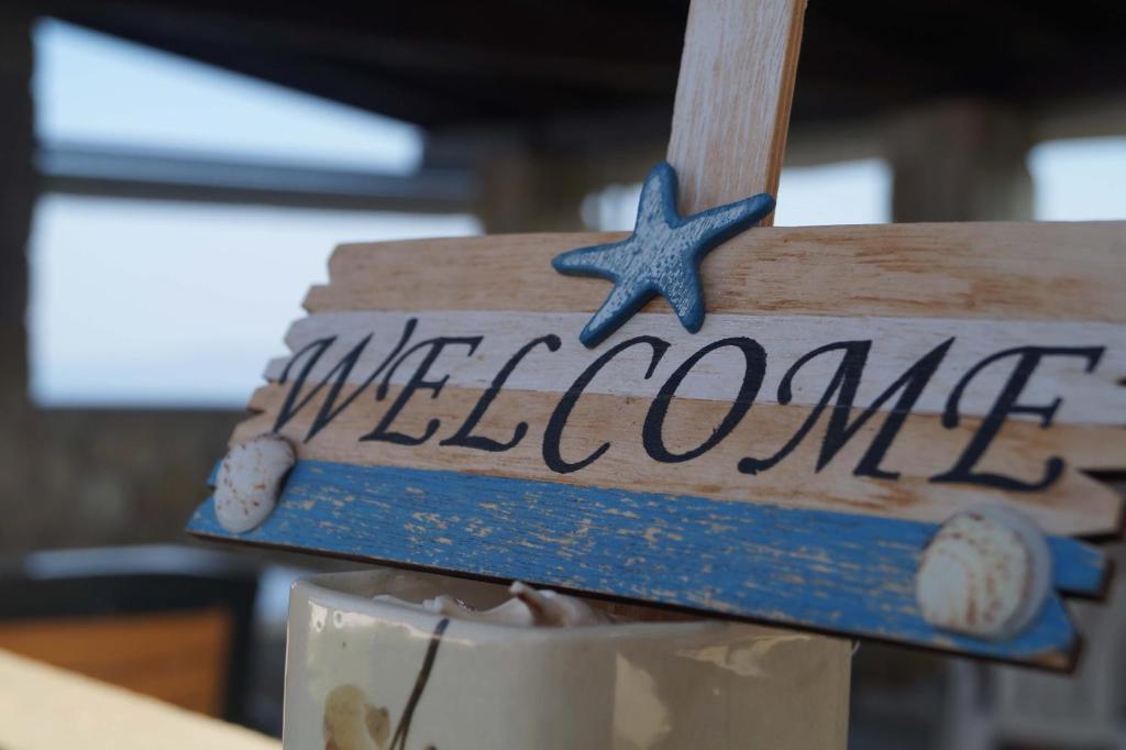 a sign that says welcome with a starfish on it at Poseidon Seaview Studios in Afitos