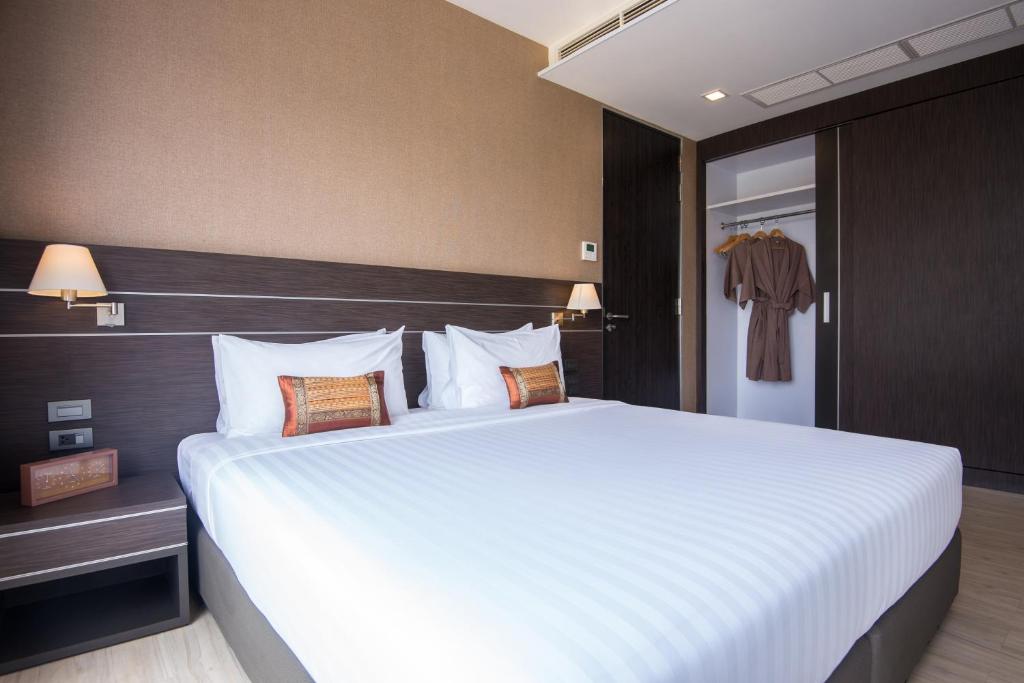 a bedroom with a large bed with white sheets at Amanta Hotel Nongkhai in Nong Khai