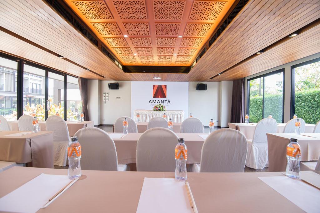 a conference room with white tables and chairs and windows at Amanta Hotel Nongkhai in Nong Khai