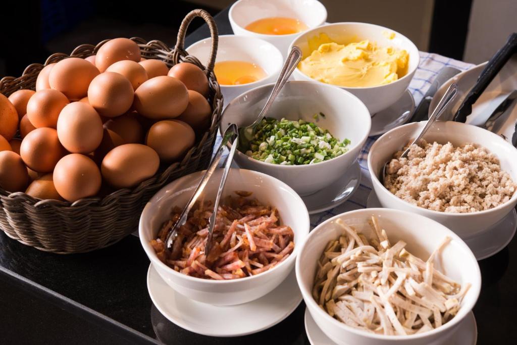 a table topped with bowls of different types of food at Amanta Hotel Nongkhai in Nong Khai