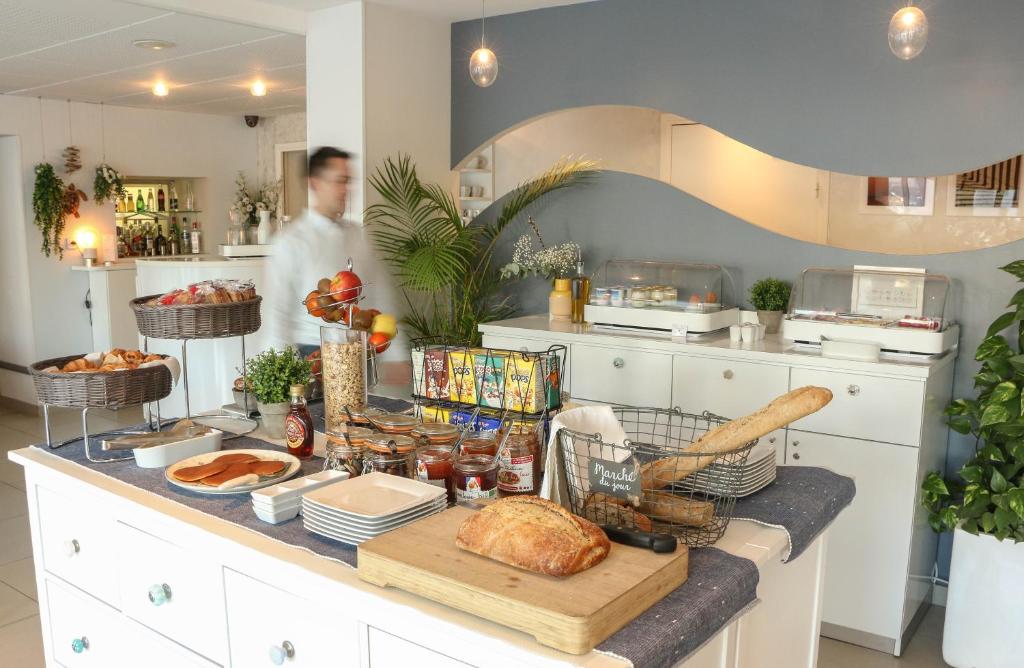 a man standing in a kitchen with a table full of food at Hôtel Josse in Antibes