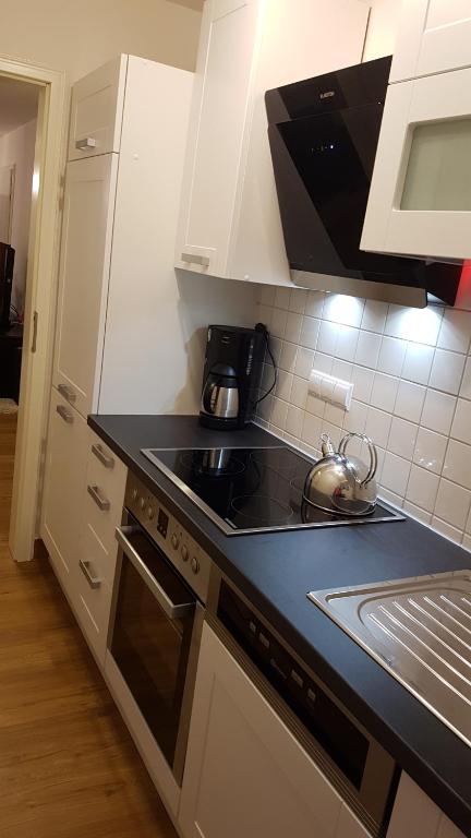 a kitchen with a black counter top and a stove at Ferienwohnung "Waldeck" Nahe Messe und Bodensee in Friedrichshafen
