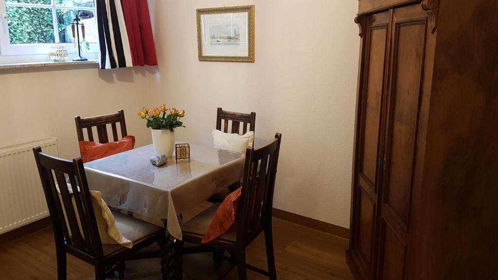 a dining room table with a vase of flowers on it at Ferienwohnung "Waldeck" Nahe Messe und Bodensee in Friedrichshafen