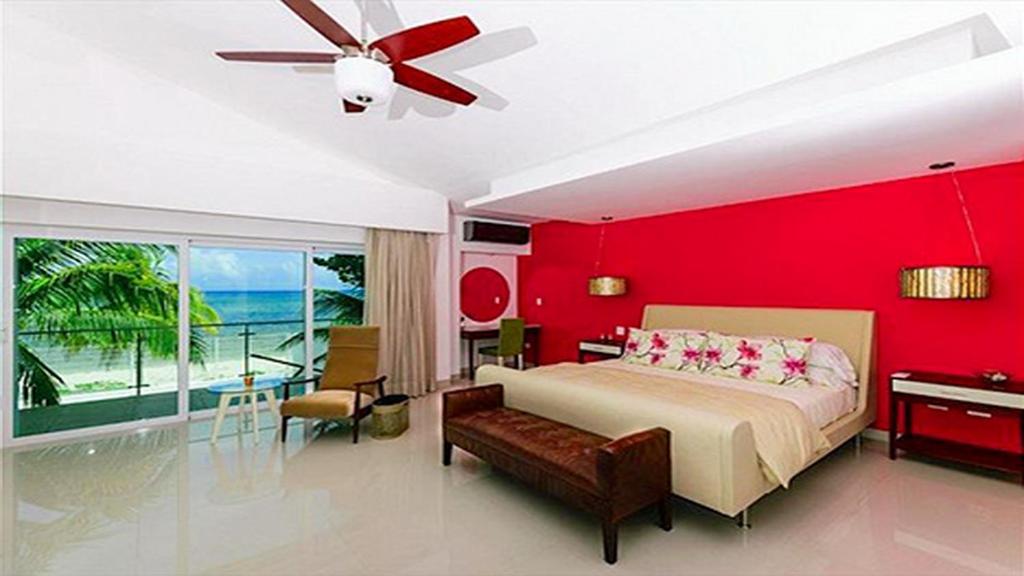 1 dormitorio con pared roja, cama y mesa en CortesStars, en Cancún