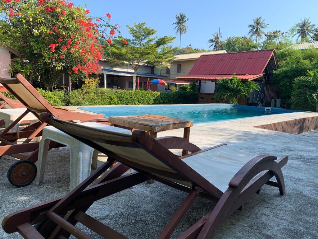 a chair and a table next to a swimming pool at Phi Phi Little Star Resort in Phi Phi Don