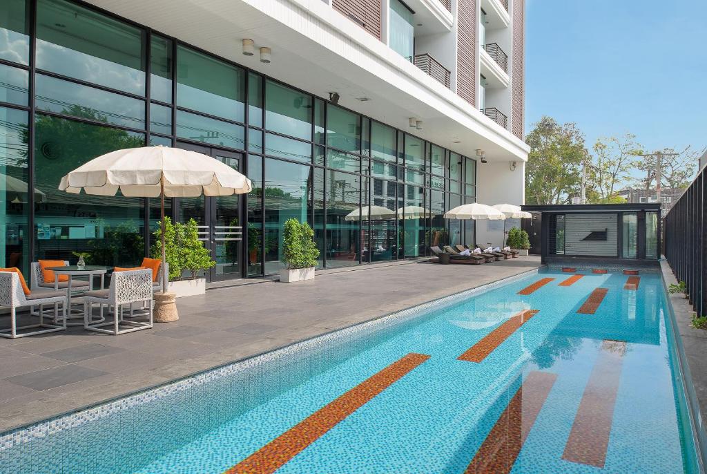 a swimming pool in front of a building at Tsix5 Hotel in North Pattaya