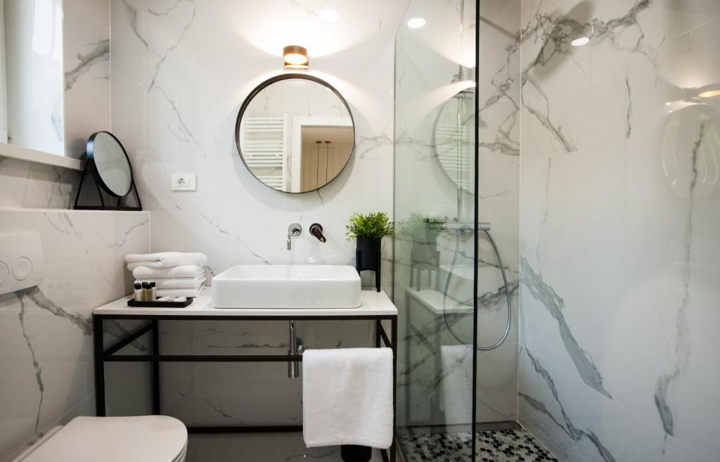 a bathroom with a sink and a shower at Club boutique rooms in Split