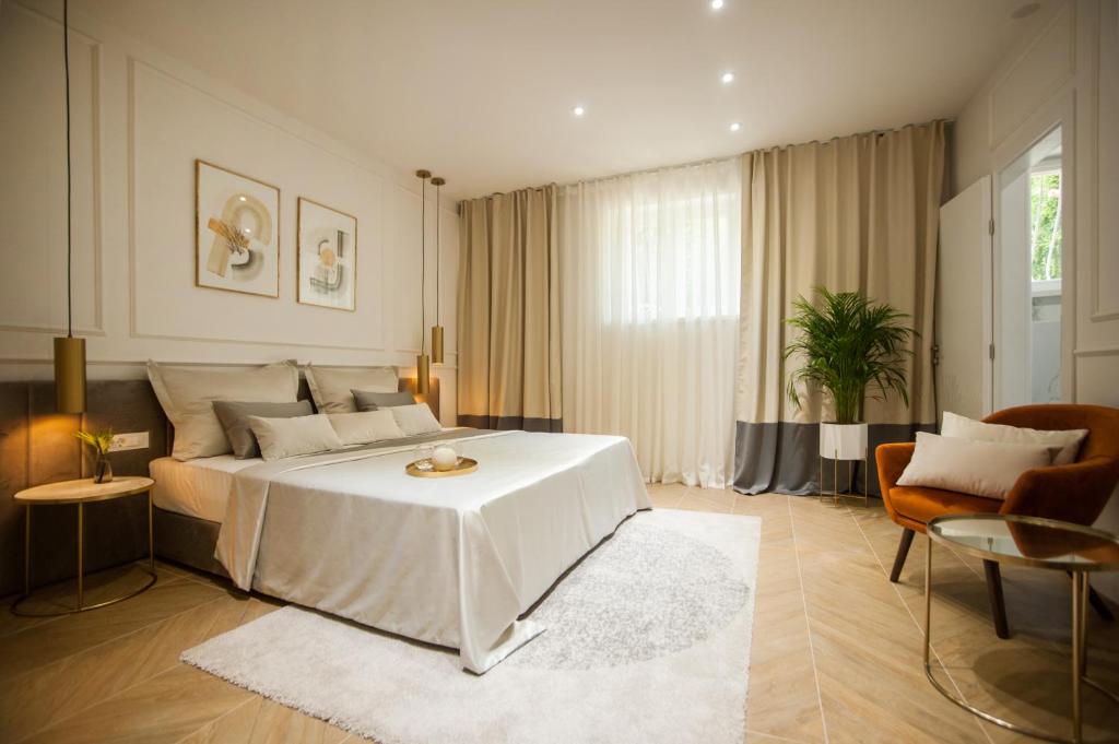 a bedroom with a white bed with a white table at Club boutique rooms in Split