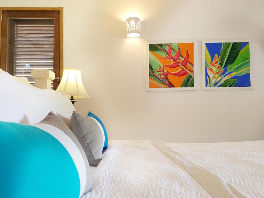 a bedroom with a bed and two pictures on the wall at Gingerbread Suites in Port Elizabeth
