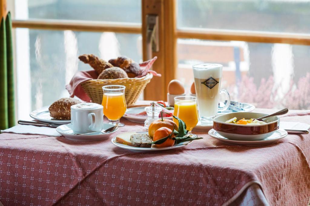 a table with breakfast foods and drinks on it at Hotel Klarer in Zuoz
