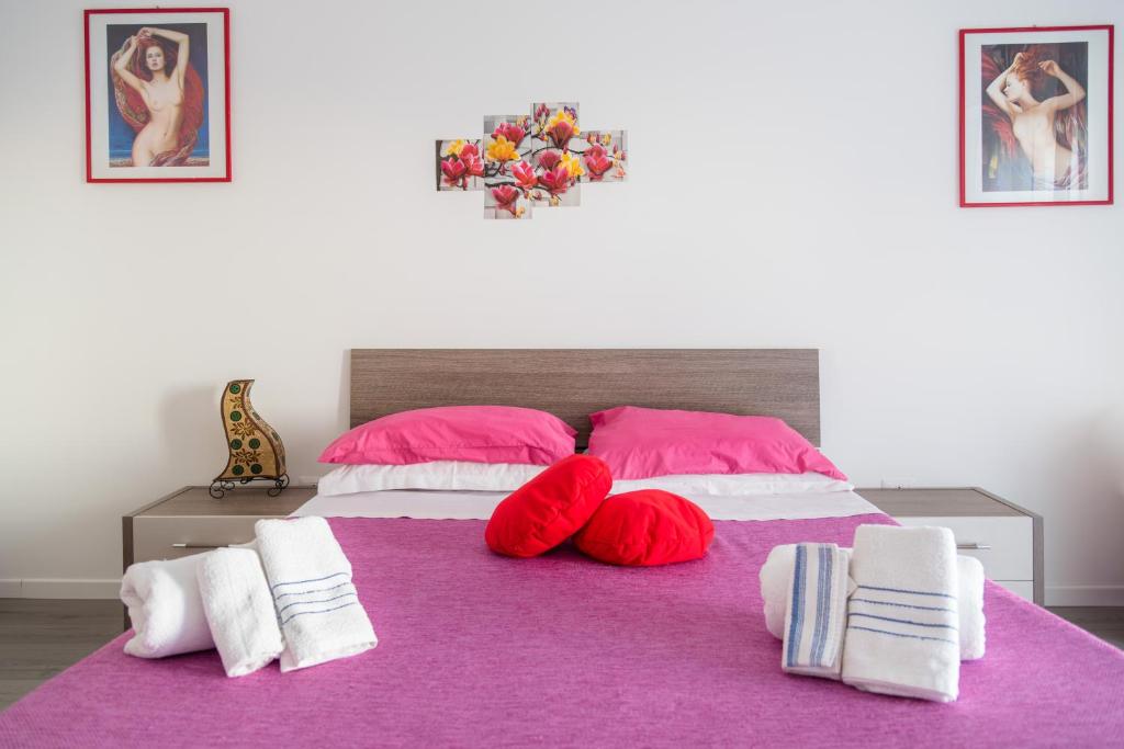 ein Schlafzimmer mit einem lila Bett mit rosa Kissen in der Unterkunft Casa Gentile in Syrakus