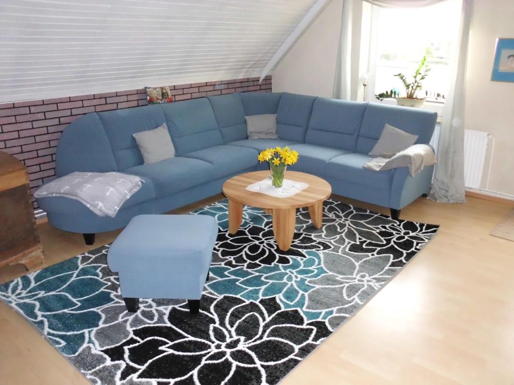 sala de estar con sofá azul y mesa en Petra Kappler, en Osterby