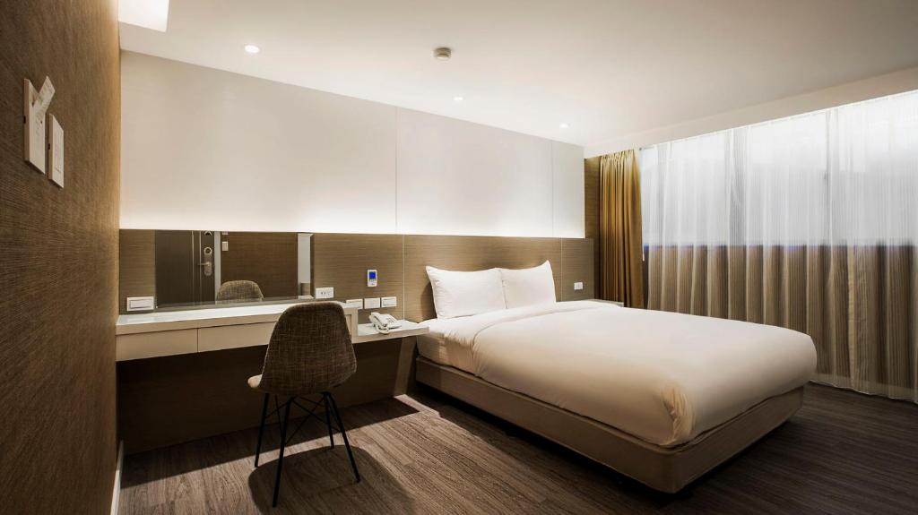 台北的住宿－蒲園飯店，酒店客房配有一张床和一张带椅子的书桌