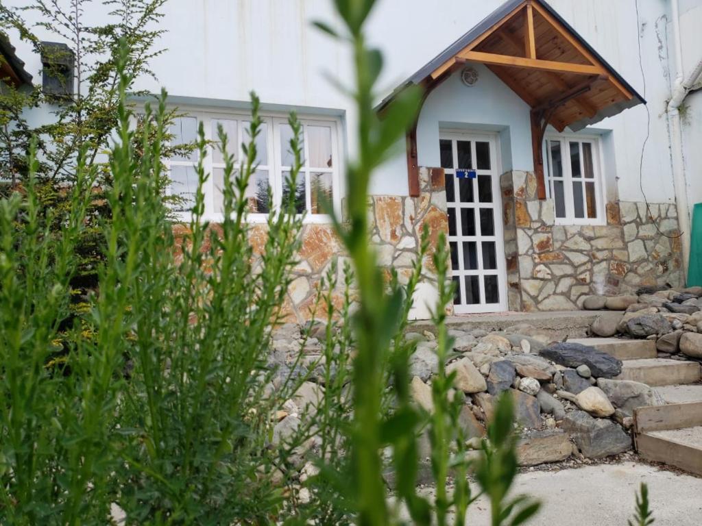 ein Haus mit einer Steinmauer und einer Tür in der Unterkunft Departamentos Del Bosque in Ushuaia
