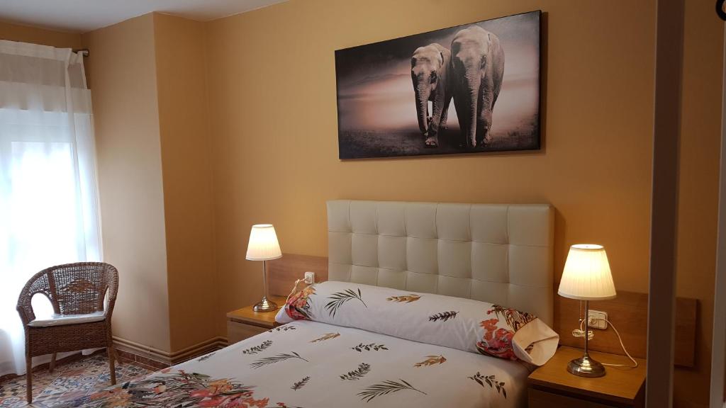 ein Schlafzimmer mit einem Bett und einem Bild eines Elefanten in der Unterkunft La Casa de Elena in Gijón