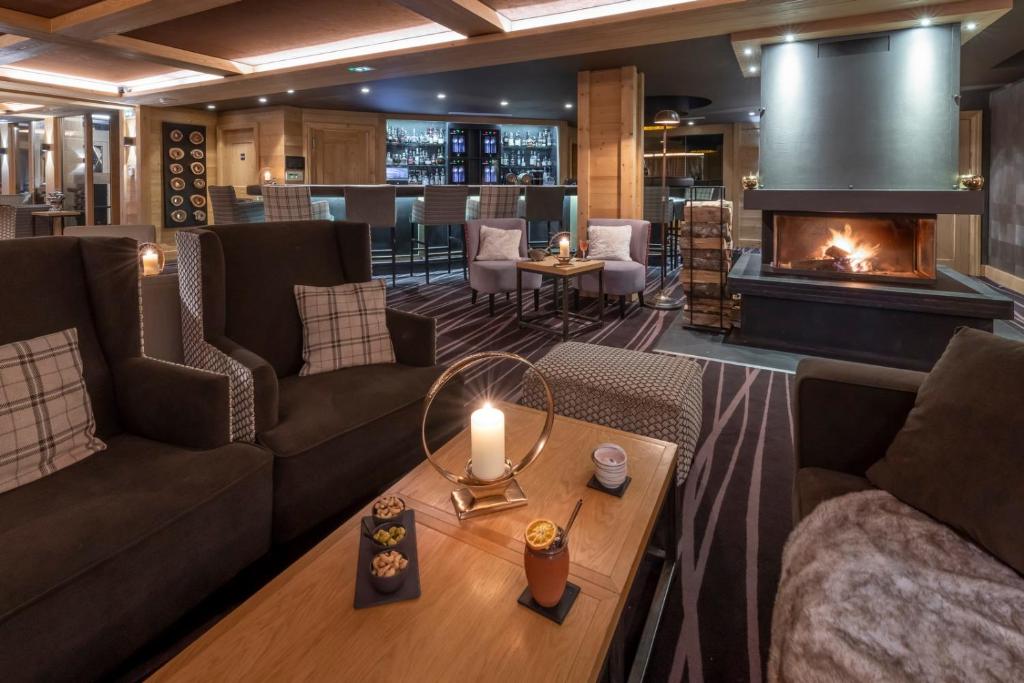 a living room with couches and a fireplace at Le Kaïla in Méribel