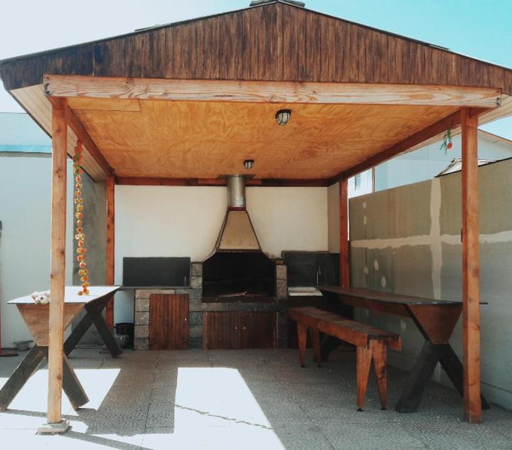 a wooden pavilion with a table and a bench at cabañas Dany in Concón