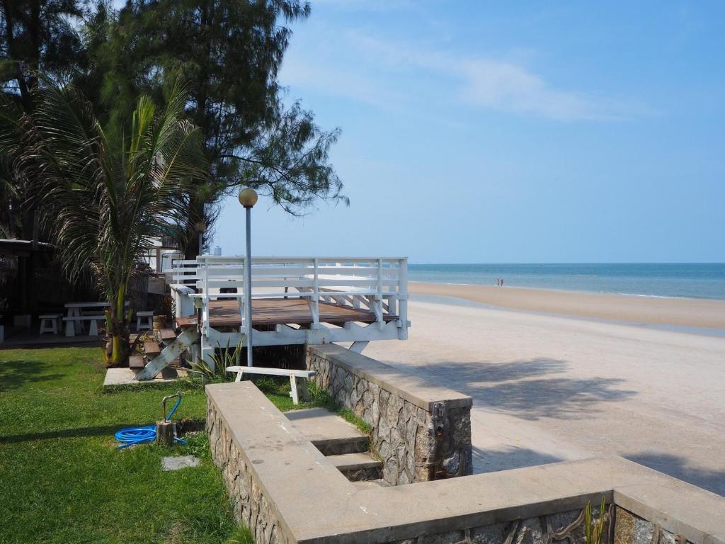 Aranava Resort Huahin في هوا هين: مقعد على الشاطئ بجوار الشاطئ