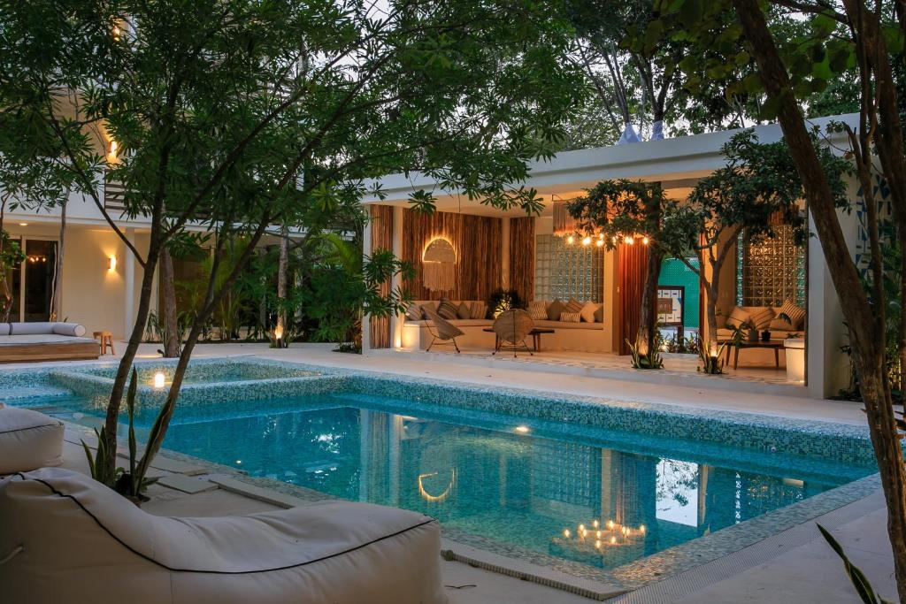 uma piscina numa casa com árvores e mobiliário em Charming Nature-Inspired Condos with Sultry Surroundings by Stella Rentals em Tulum