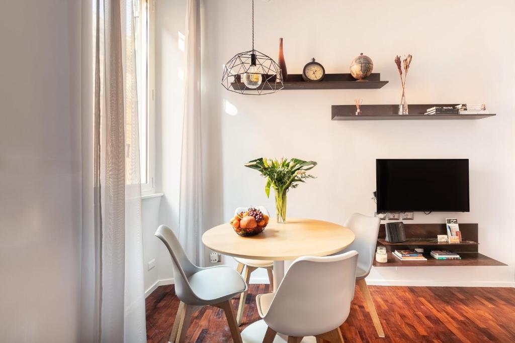 ローマにあるLiving RHome - Condotti Apartmentのダイニングルーム(テーブル、椅子、テレビ付)