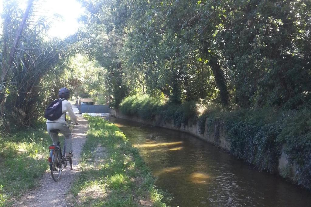 a person riding a bike down a river at Gîte du Mas Arnaud in Thuir