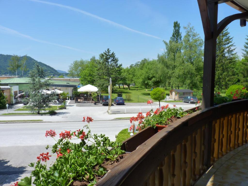 a balcony with flowers and a street in the background at Das Alpensee in Unterburg am Klopeiner See