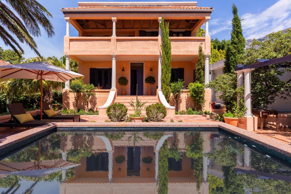una villa con piscina di fronte a una casa di Kensington Views a Città del Capo