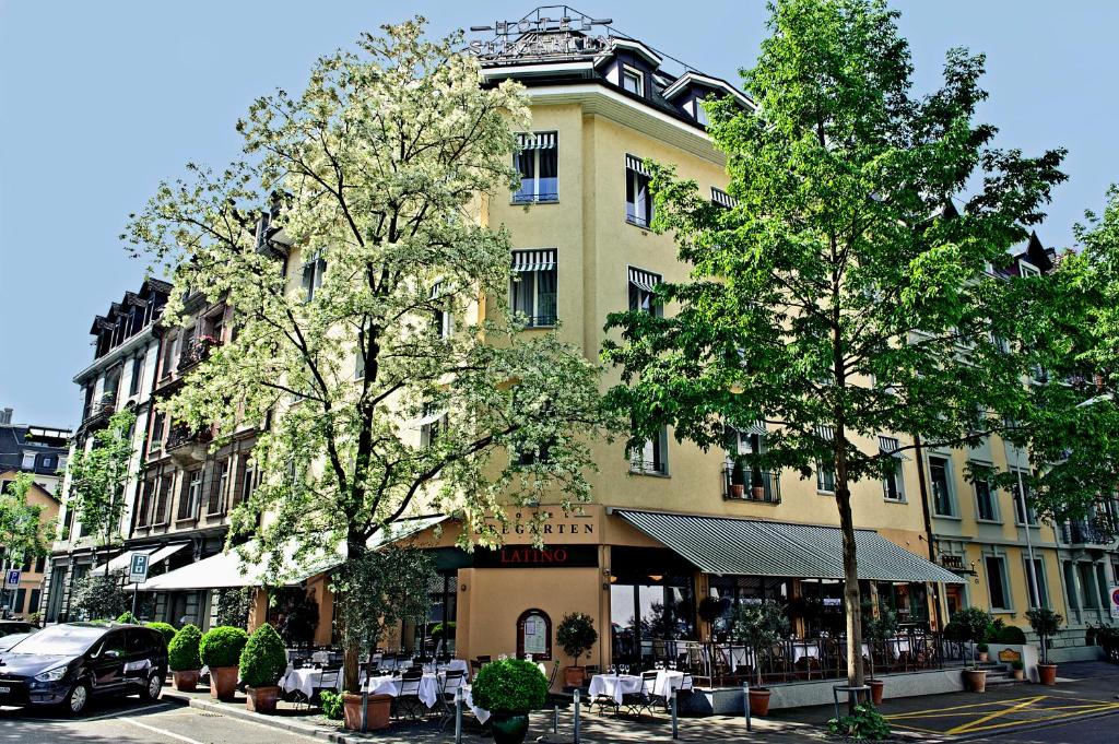 a building on a street with trees in front of it at Boutique Hotel Seegarten in Zürich