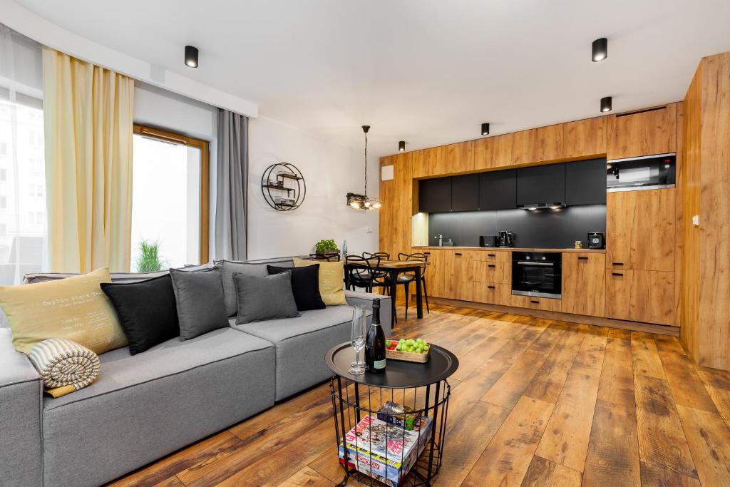 - un salon avec un canapé gris et une table dans l'établissement Apartamenty Black&White - Apartament Loft Style, à Gdynia
