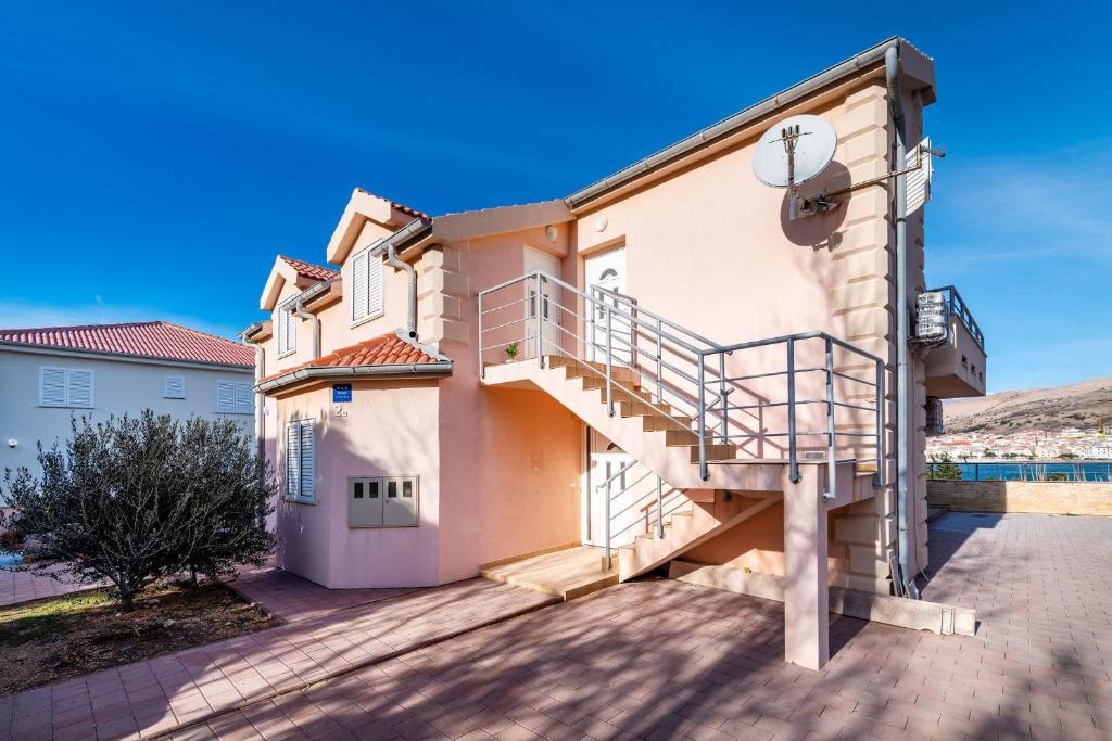 a house with a staircase on the side of it at Apartments Matej in Pag