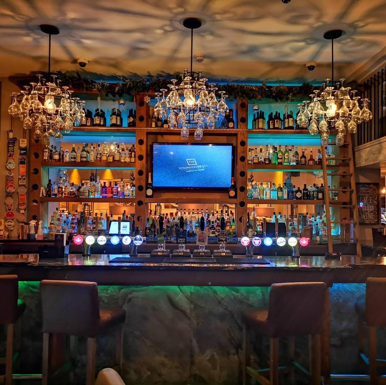 a bar with a television behind a bar at The Townhouse Boutique Hotel in Barrow in Furness