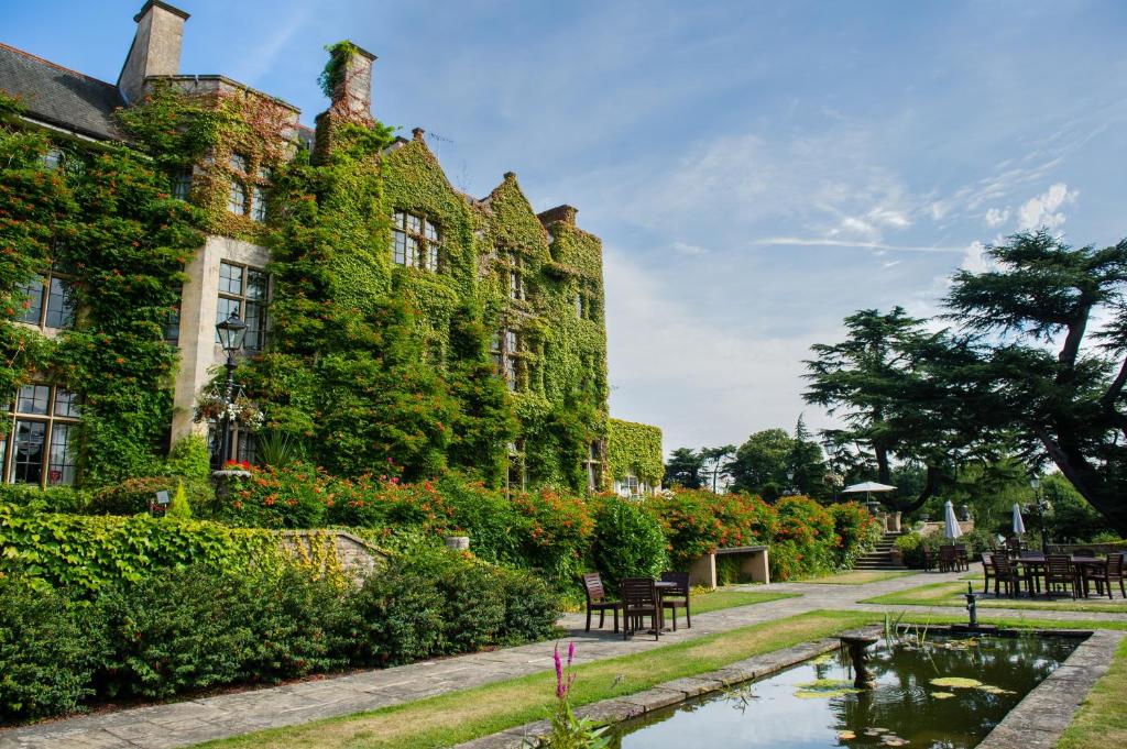 a building with a pond in front of it at Pennyhill Park Hotel and Spa in Bagshot