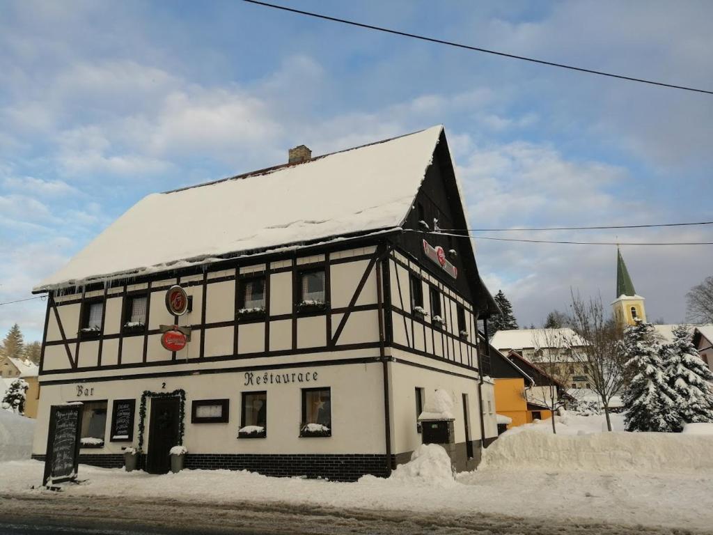 a black and white building with snow on it at Penzion Tina in Pernink