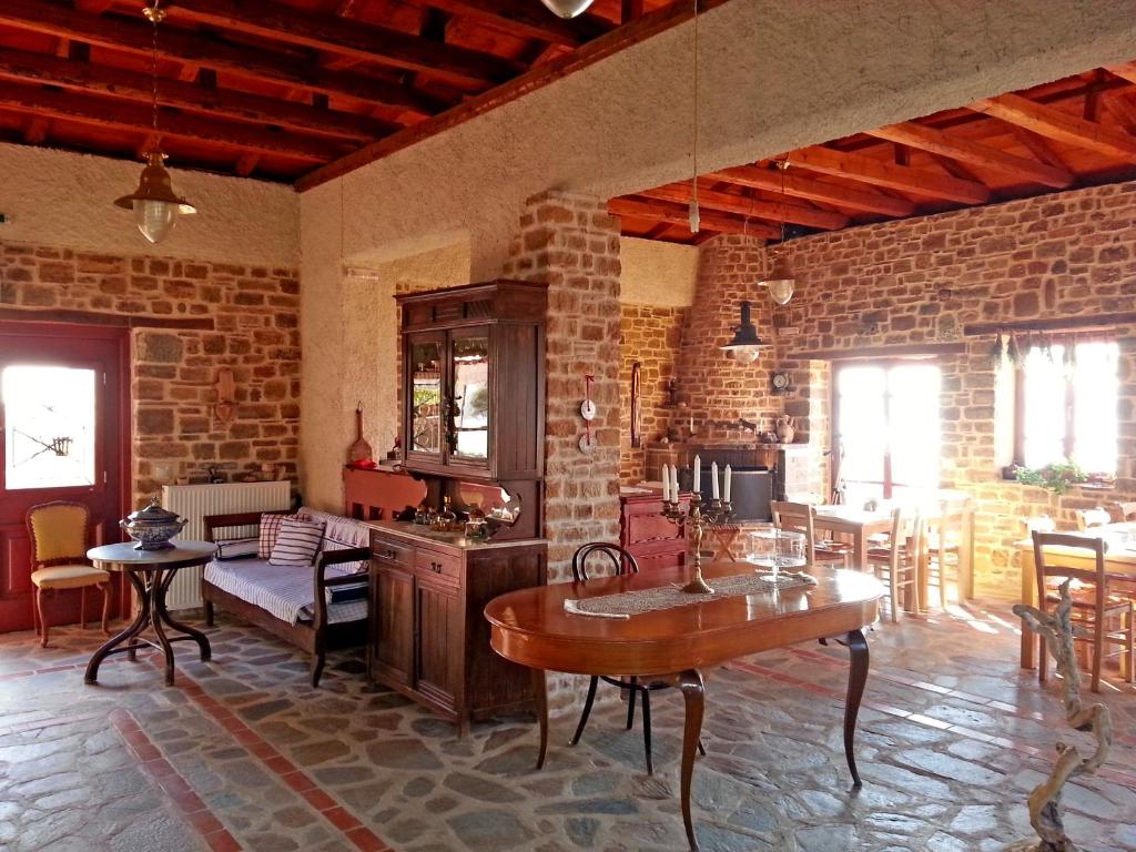 a living room with a brick wall and a table at Ethaleia Hotel in Moúdhros