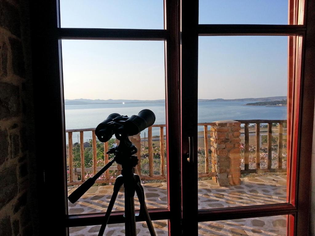 a camera on a tripod in front of a window at Ethaleia Hotel in Moúdhros