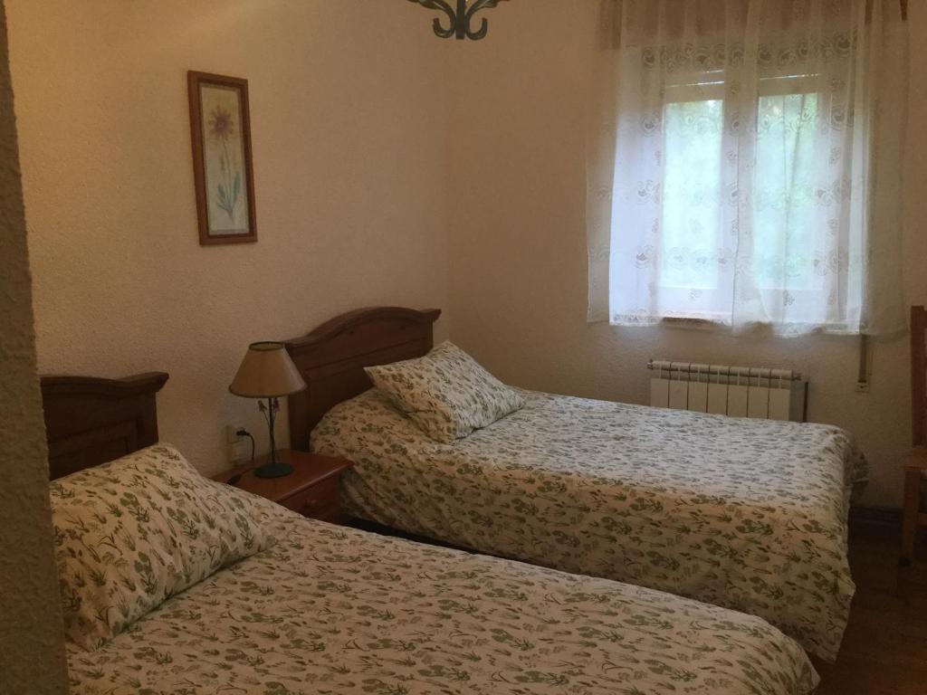 a bedroom with two beds and a window at Casa Sanabresa in Galende