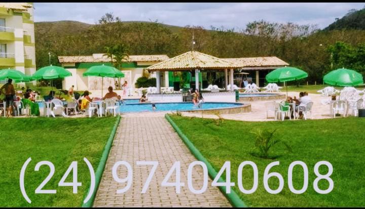 a picture of a resort with a swimming pool and green umbrellas at Aldeia das Águas Barrakana flats in Nossa Senhora das Dores