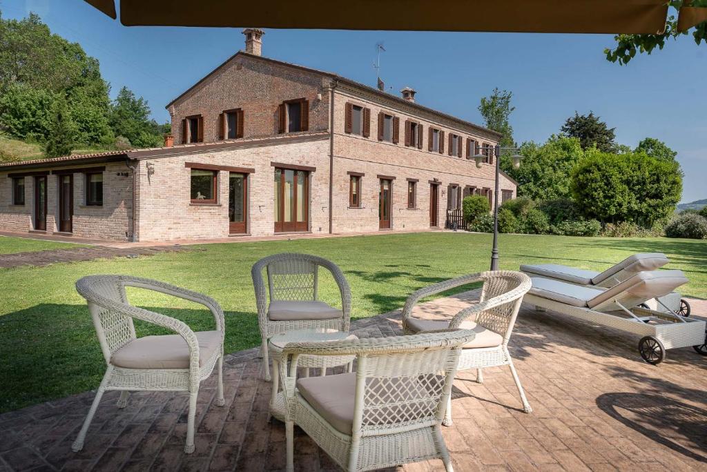 - un ensemble de chaises assises sur une terrasse en face d'une maison dans l'établissement Badia Agriturismo, à La Torraccia