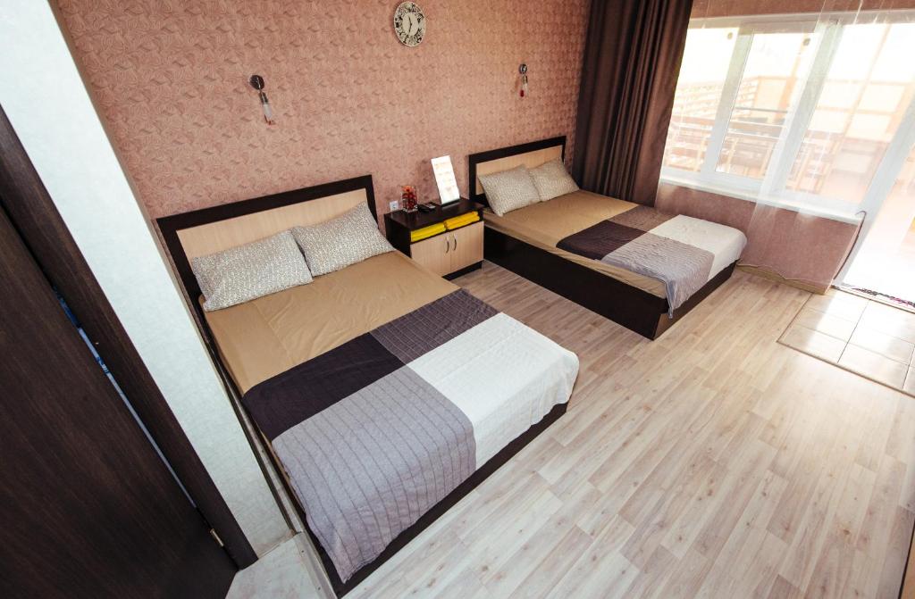 エイスクにあるApartment Na Yanyshevaのベッド2台と窓が備わるホテルルームです。