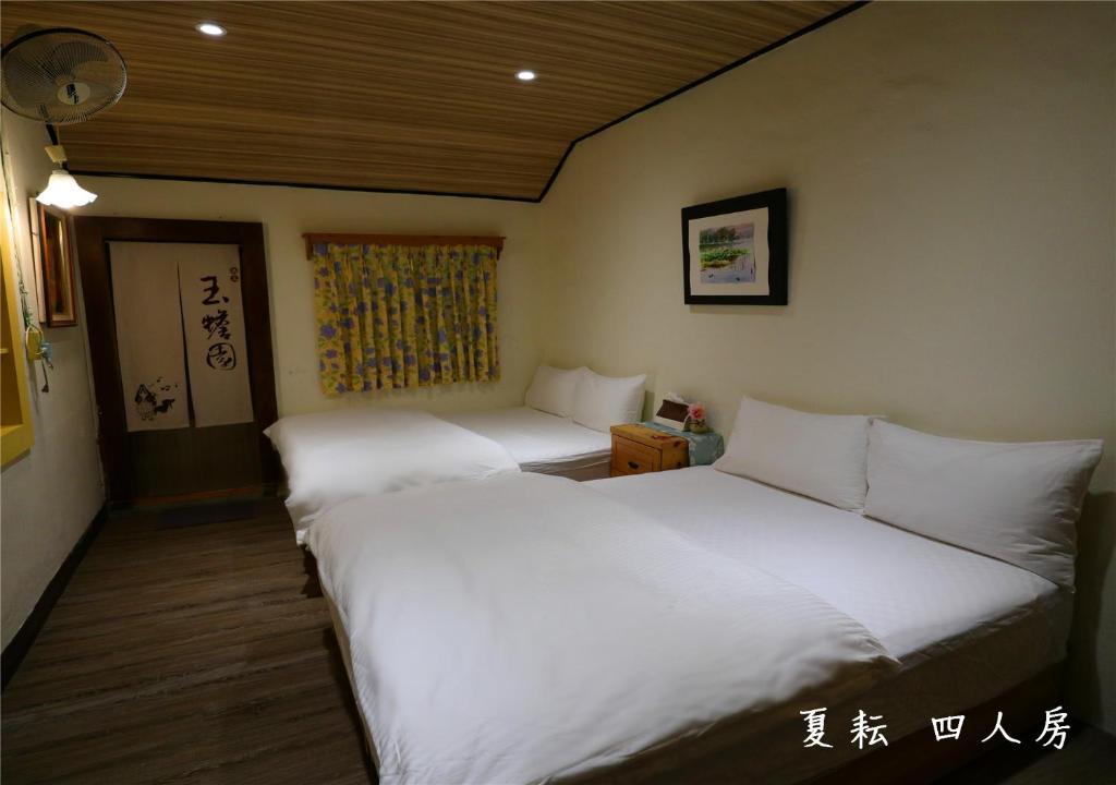 two beds in a hotel room with at 玉蟾園民宿 寵物友善 YuChanYuan B&amp;B in Chishang
