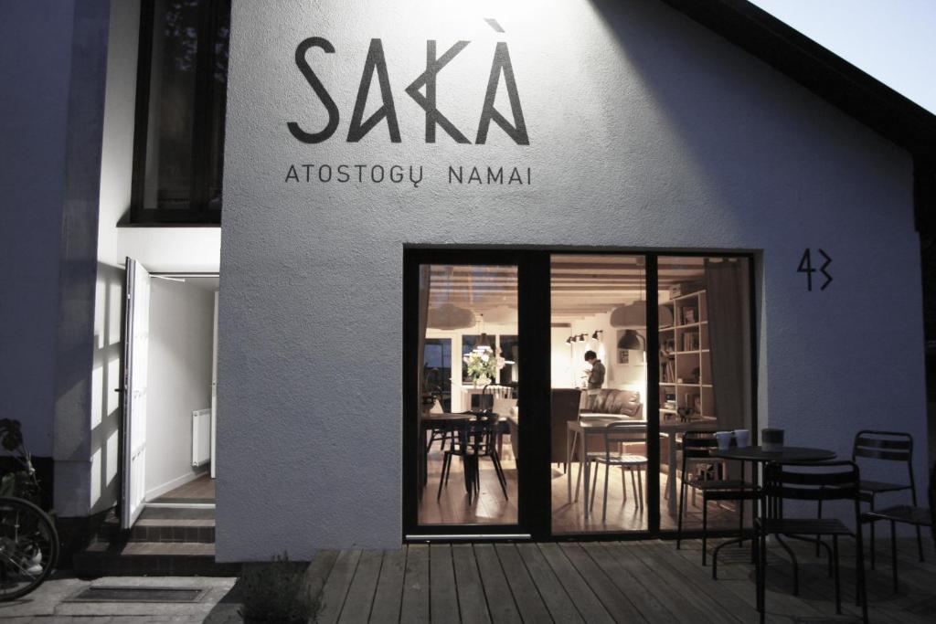 a restaurant with a sign on the side of a building at SAKÀ Vacation House in Druskininkai