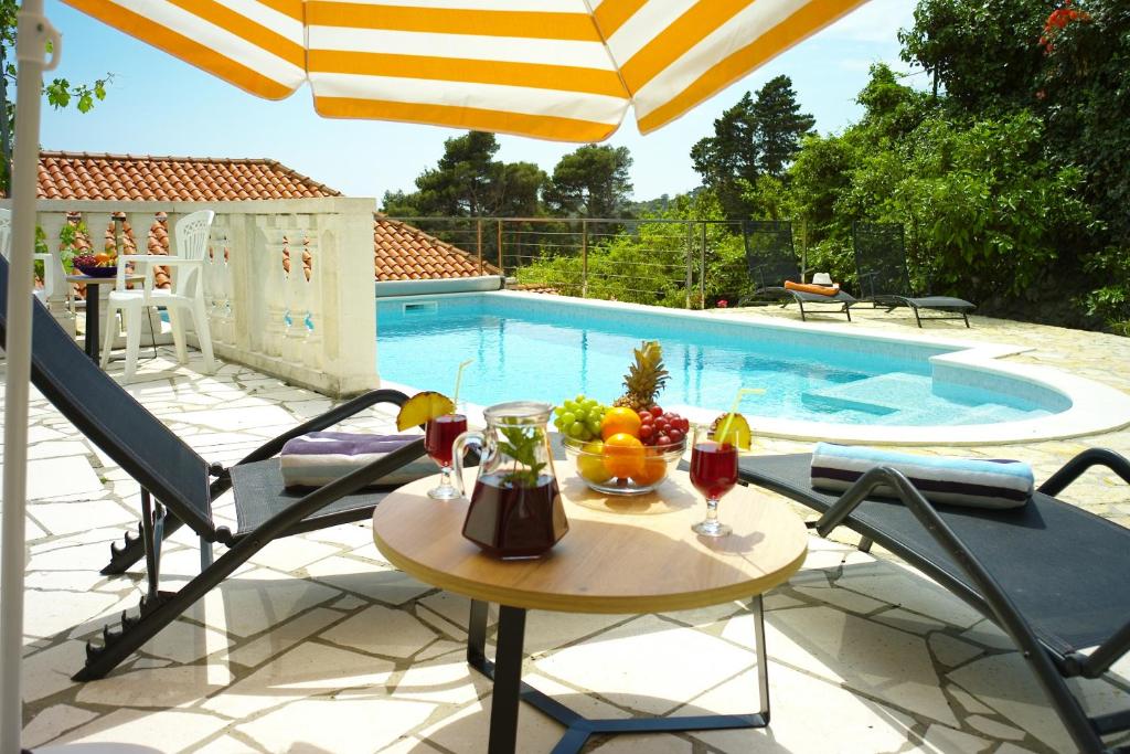 una mesa con copas de fruta y vino en un patio en Villa Vinki, en Mlini