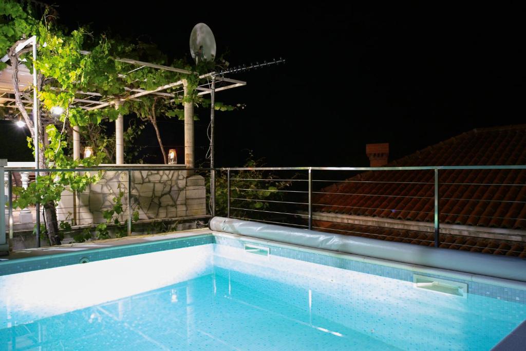 a swimming pool at night with a fence at Villa Vinki in Mlini