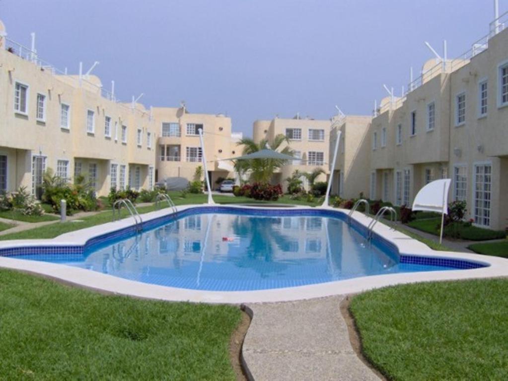 a swimming pool in the middle of a yard with buildings at Hermosa Casa Acapulco Diamante Hospedaje a 5 min de la playa in Acapulco