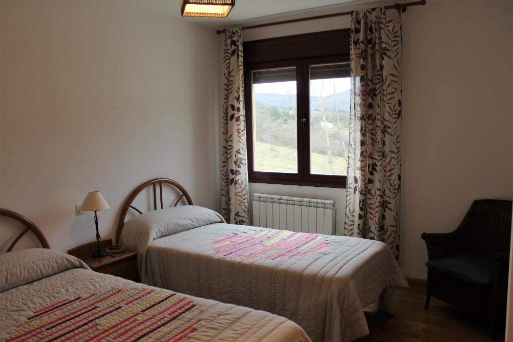 1 dormitorio con 2 camas y ventana en Apartamento Usarena en Ezcaray, en Zorraquín