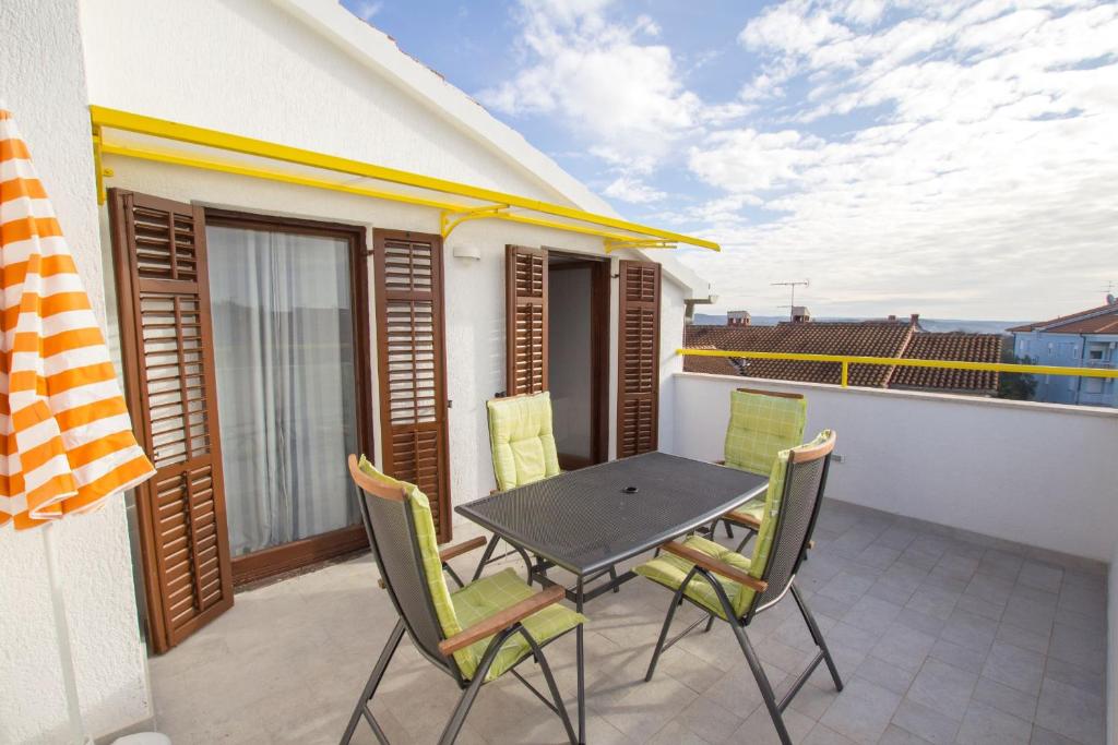 patio con mesa y sillas en el balcón en Apartments and Rooms Irena, en Rovinj