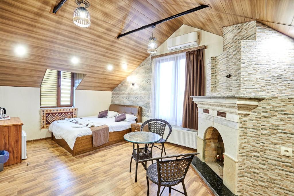 a hotel room with a bed and a fireplace at Hotel Diadema in Tbilisi City