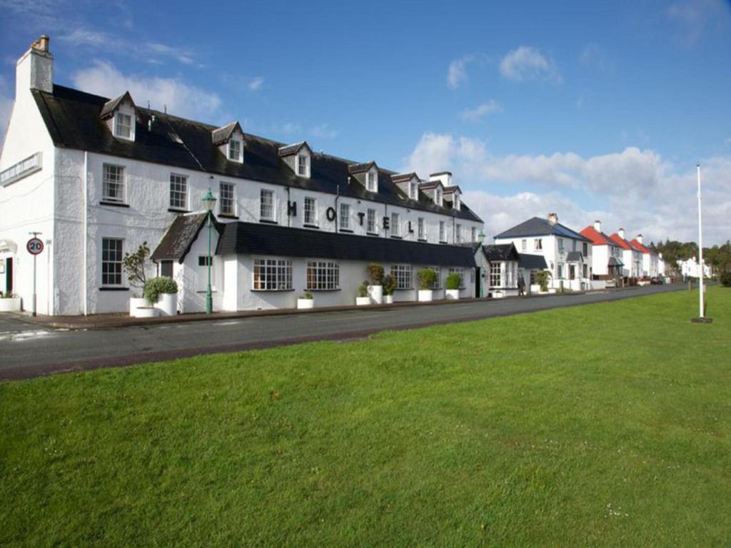 a large white building on the side of a street at Kings Arms Hotel - A Bespoke Hotel in Kyleakin