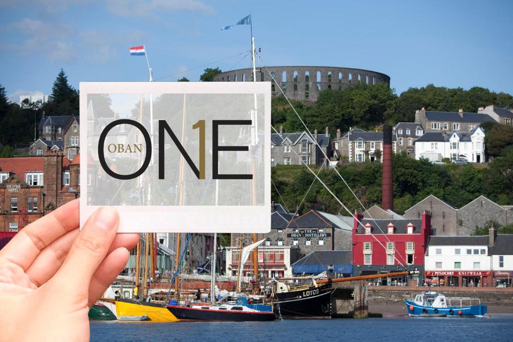 a hand holding up a sign that reads one at One Oban in Oban